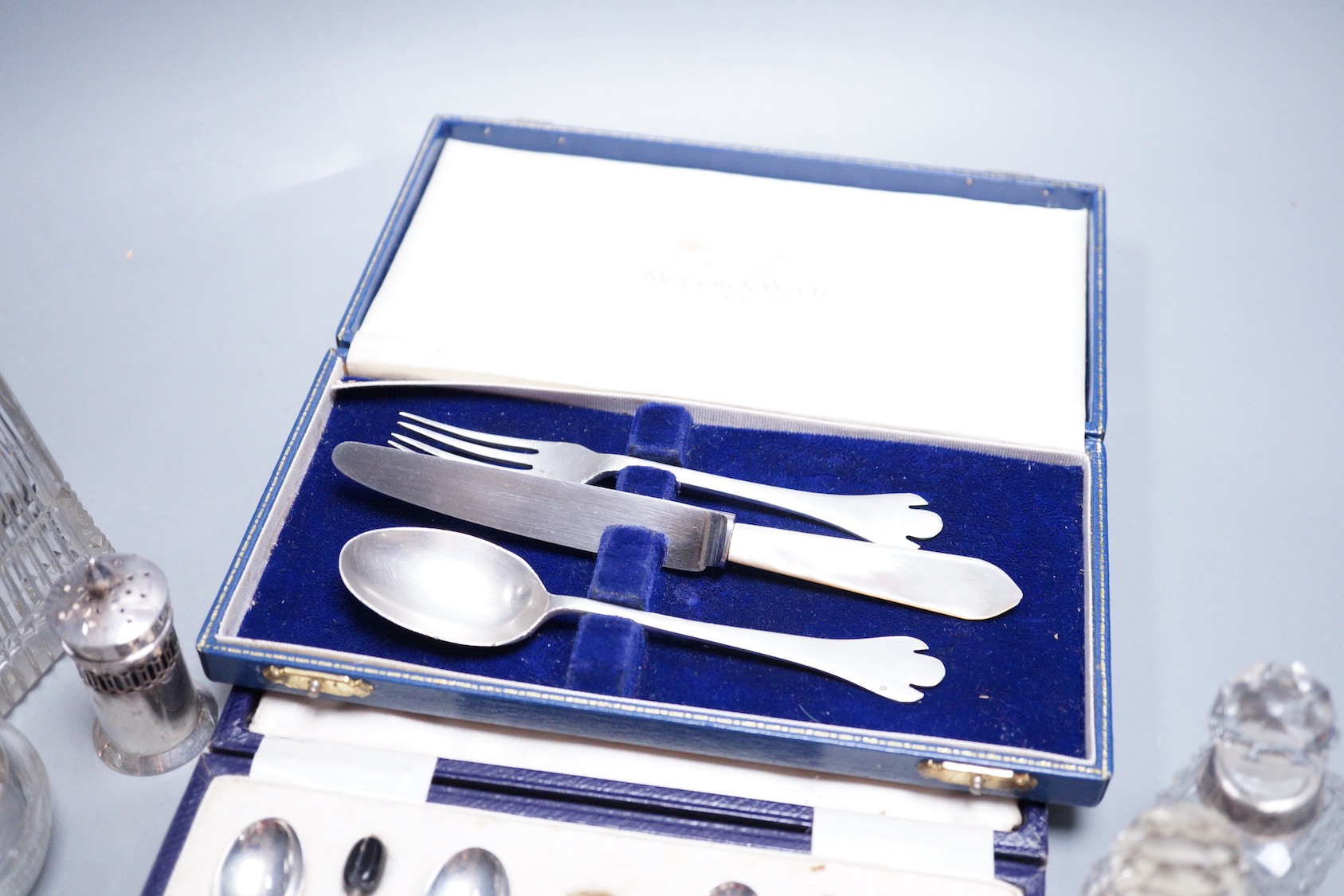 A modern 17th century style silver dog nose christening spoon and fork by Mappin & Webb, an associated knife, a cased set of six silver bean end coffee spoons (lacking tongs), a silver three piece condiment set and five